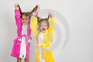 Two girls in the bath robes raised their wet hair