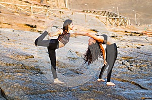 Two girls on the beach doing yoga at sunset. Lima Peru.