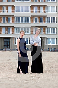 Two girls beach sand apartment building, De Panne, Belgium