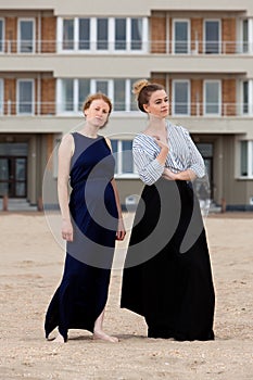 Two girls beach sand apartment building, De Panne, Belgium