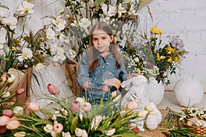 Two girls in a beautiful Easter photo zone with flowers, eggs, chickens and Easter bunnies. Happy Easter holiday.