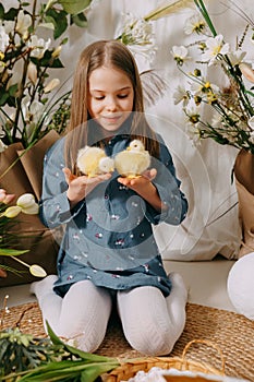 Two girls in a beautiful Easter photo zone with flowers, eggs, chickens and Easter bunnies. Happy Easter holiday.