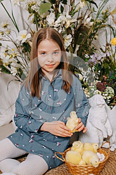 Two girls in a beautiful Easter photo zone with flowers, eggs, chickens and Easter bunnies. Happy Easter holiday.