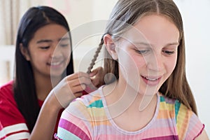 Two Girls In Bedroom Braiding Each Others Hair