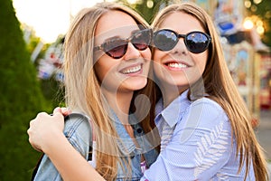 Two girls, best friends, happily hug each other.