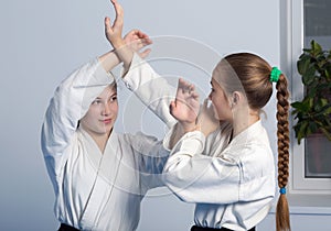 Two girls in black hakama practice Aikido