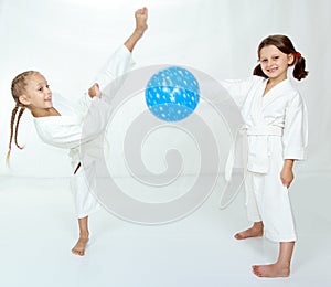 Two girls with blue ball beat karate kick
