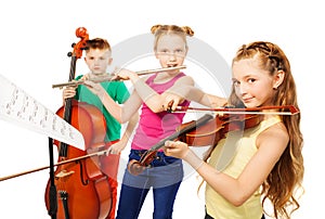 Two girls and boy playing on musical instruments