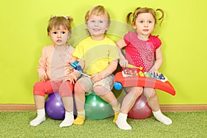 Two girls and a boy sitting on a colorful