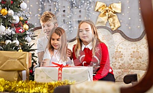 Two girls and boy on sofa in Christmas interior