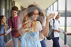 Two girls celebrating exam results in school corridor photo