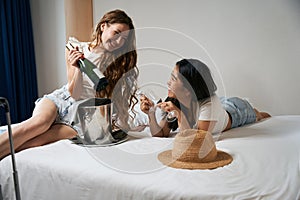 Two girls celebrating a trip in a hotel room