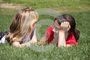 Two girls chatting in grass