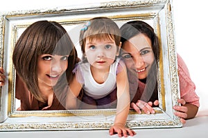 Two girls and child holding wooden white frame