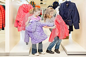 Two girls choose clothes in a store