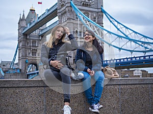 Two girls on a city trip to London - relax at the Tower Bridge