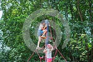 Two girls climb up on the ropes