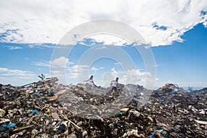 Two girls climbing among mountains of trash