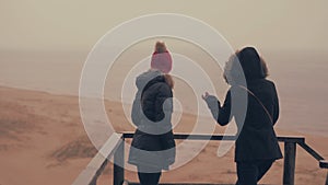 Two girls enjoys rain in a spring forest near sea. 60 to 24fps 4K UHD