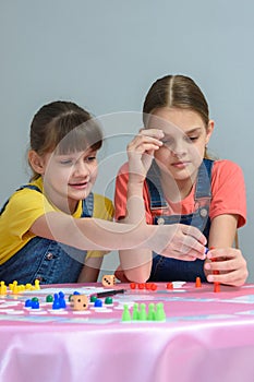 Two girls enthusiastically play a board game