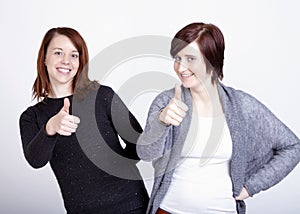 Two girls friends gesturing thumb up