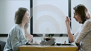 Two girls gossiping in a Japanese restaurant