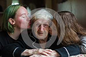Two girls granddaughter kissing her grandmother. Love.