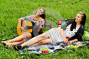 Two girls with guitar during picnic