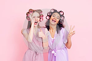Two girls with hair curlers. They are celebrating women`s day March 8.