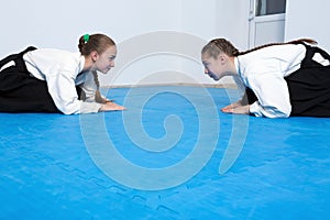 Two girls in hakama bow on Aikido training