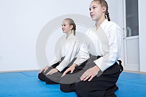 Two girls in hakama sitting on Aikido training