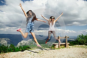 Two girls happy jump in mountains