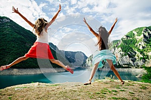 Two girls happy jump in mountains