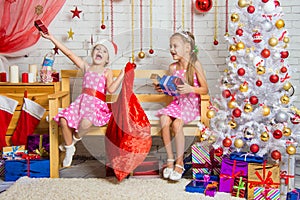 Two girls having fun and happy New Year gifts from Santa Claus bag