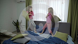 Two girls having pillow fight