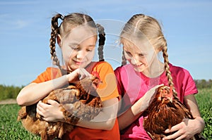 Two girls holding chickens