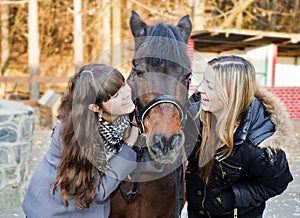 Two girls holding a horse