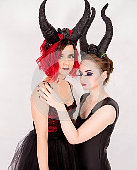 Two girls with horns on head posing in front of camera