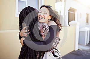 Two girls hugging on sidewalk, feeling joyful and happy together. Female friends embracing and greeting each other on