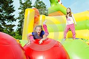 Two Girls Jumping on Inflate Castle photo
