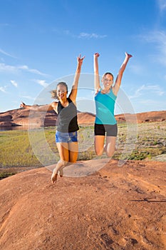 Two Girls Jumping for Joy in the Desert