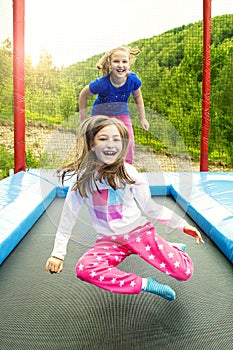 Two Girls Jumping on Trampoline