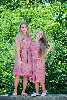 two girls kids in retro dress embrace outdoor, sisterhood