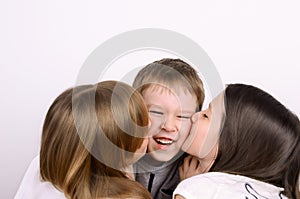 Two girls kissing little laughing boy