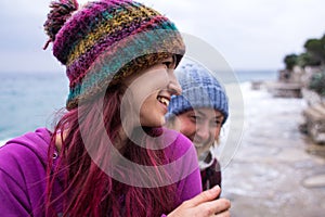 Two girls laugh on the beach while walking