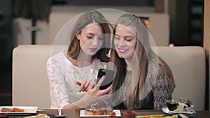 Two girls laughing and doing selfie