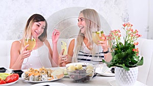 Two girls laughing girls talking on video communication on smartphone at home, selective focus