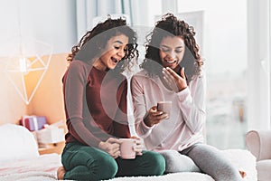 Two girls laughing while reading funny messages