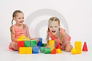 Two girls laughing uncontrollably playing dice