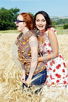 Two girls laughing in wheat field